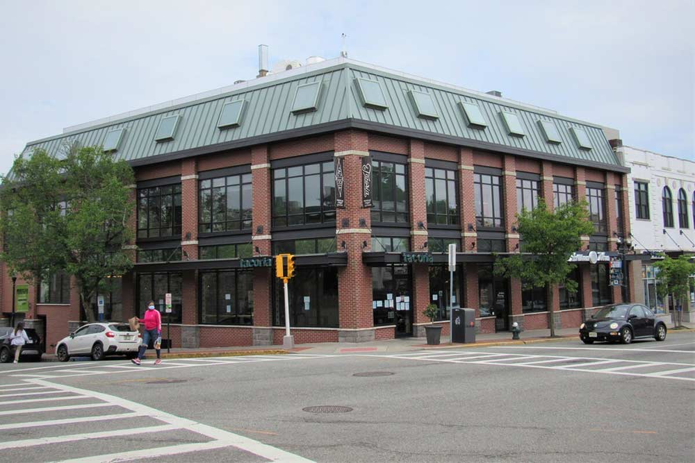 corner building with red brick columns supporting large glass windows